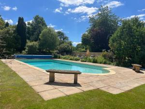a swimming pool with a bench in a yard at Gamekeeper's Cottage in Dorchester