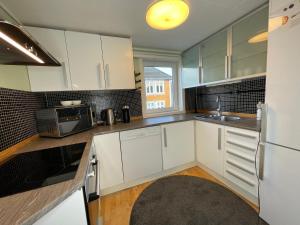 eine Küche mit weißen Schränken und einem Waschbecken in der Unterkunft Stavanger Bnb nicolas 10 Terrace 2bed Rooms in Stavanger
