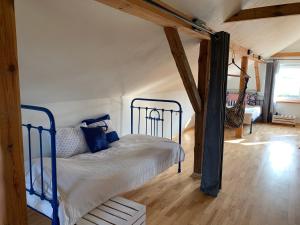 una camera con un letto in una stanza con pavimenti in legno di Siedlisko Wiłkupie, Dom nad stawem a Wiżajny