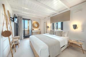 Éxo GoniáにあるEscape View Villa with private pool by Caldera Housesの大きなベッドとテーブルのある白い寝室