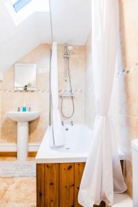 a bathroom with a shower and a sink and a tub at Thursdays Corner Tudor Cottage in Church Stretton +38 photos