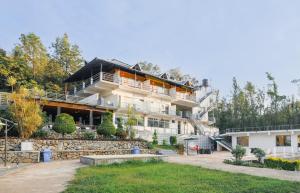 a large white building with a garden in front of it at The Blossom Resort - Chikmagalur in Chikmagalūr