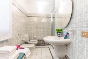 San Lorenzo Five Senses في فلورنسا: حمام أبيض مع حوض ومرحاض