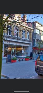 a building on a street with benches in front of it at Gastenverblijf De Arend in Nieuwpoort