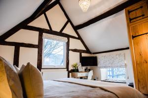 a bedroom with a large bed and a window at Thursdays Corner Tudor Cottage in Church Stretton