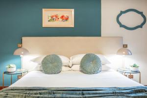 San Lorenzo Five Senses في فلورنسا: غرفة نوم بسرير ابيض بجدران زرقاء