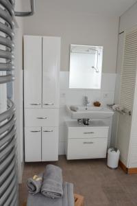 a white bathroom with a sink and a mirror at Gartenblick in Leichlingen
