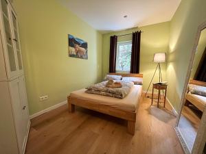 ein Schlafzimmer mit einem Bett in einem Zimmer mit grünen Wänden in der Unterkunft Gartenblick in Leichlingen