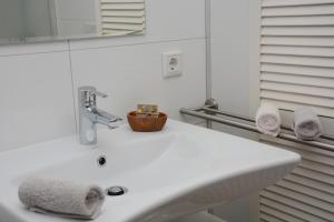 ein Badezimmer mit einem weißen Waschbecken und einem Spiegel in der Unterkunft Gartenblick in Leichlingen