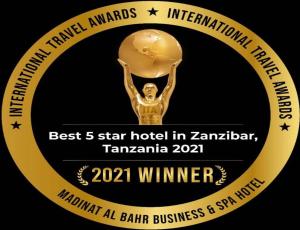 a gold medal of a man holding a trophy at Madinat Al Bahr Business & Spa Hotel in Zanzibar City
