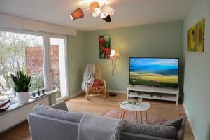 ein Wohnzimmer mit einem Sofa und einem Flachbild-TV in der Unterkunft Gartenblick in Leichlingen
