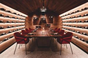 a dining room with a long table and red chairs at Boutique Hotel Nives - Luxury & Design in the Dolomites in Selva di Val Gardena