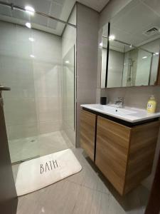 a bathroom with a shower and a sink and a bath rug at Modish Classy Apartment In Jumeirah in Dubai