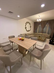 a living room with a wooden table and chairs at Modish Classy Apartment In Jumeirah in Dubai