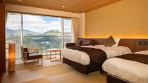 pokój hotelowy z 2 łóżkami i dużym oknem w obiekcie Enakyo Onsen Hotel Yuzuriha w mieście Ena