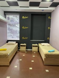 Pavlohrad的住宿－ГРК РЕЛАКС，墙上有黄色写字的房间里,有两张床
