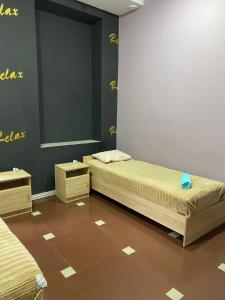 two beds in a room with yellow writing on the wall at ГРК РЕЛАКС in Pavlohrad