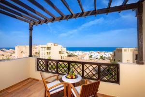 a balcony with a table and chairs and a view of the ocean at Zen Resort Sahl Hasheesh by TBH Hotels in Hurghada