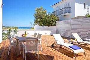 um pátio com uma mesa e cadeiras num deque em Sunrise Seaview Villas - Camelia em Paralimni