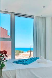 a bedroom with a bed with a view of the ocean at Sunrise Seaview Villas - Camelia in Paralimni