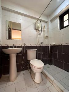 a bathroom with a toilet and a sink at Piña Colina Resort in Tagaytay