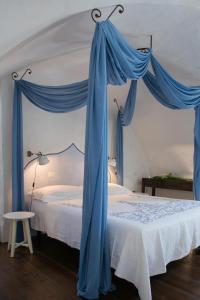 ラーカレにあるDimore Santagaetaのベッドルーム1室(青い天蓋付きのベッド1台付)