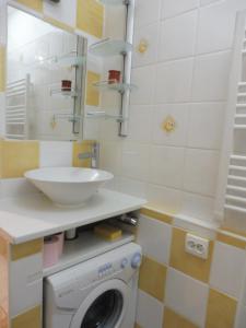 een badkamer met een wasmachine en een wastafel bij ABBAYE DU CAP Très joli T2 moderne proche port ABBAYE DU CAP Cap d'Agde in Cap d'Agde