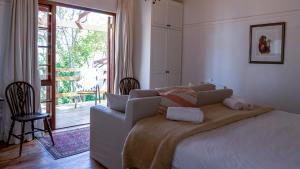een slaapkamer met een bed en een glazen schuifdeur bij Eastcliff Cottage in Hermanus