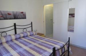 una camera da letto con un letto con un piumone a righe di Lovely Flat in Northern Sardinia (Valledoria) a Valledoria