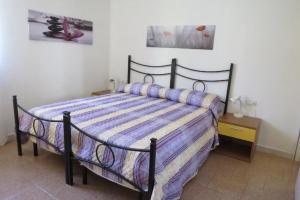 una camera da letto con un letto con un piumone a righe di Lovely Flat in Northern Sardinia (Valledoria) a Valledoria