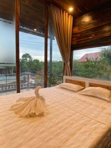a bedroom with a large bed with a large window at Rice straw Green lodge- resort in Quan Tom