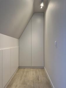 an empty room with white walls and wooden floors at Sea Breeze 303 in Nieuwpoort