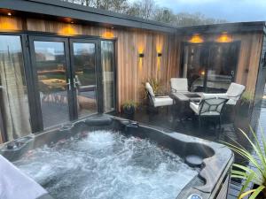 a hot tub in the middle of a patio at The Cabin@TyddynUcha in Caernarfon