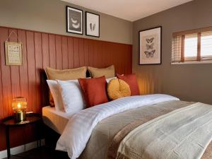 1 dormitorio con 1 cama grande y almohadas coloridas en The Cabin@TyddynUcha, en Caernarfon