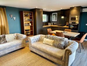 a living room with two couches and a table at The Cabin@TyddynUcha in Caernarfon