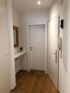 un pasillo vacío con una puerta blanca y un fregadero en Casa MÓRE en Niederalm