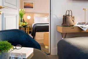 a hotel room with a bed and a blue chair at Hôtel Le Marianne in Paris