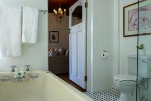 een badkamer met een ligbad en een toilet bij Eastcliff Cottage in Hermanus +16 foto's