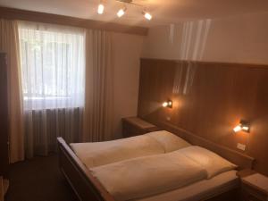a bedroom with two beds and a window at Garni Schanz in Resia