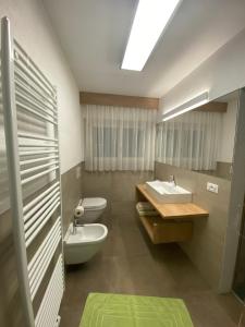 a bathroom with two toilets and a sink at Garni Schanz in Resia