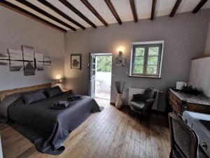 a bedroom with a bed and a table and chairs at Le Petit Moulin in Faverelles
