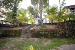 a house with a stone wall and stairs in front at Chef Naturelle's Guest House in Kandy