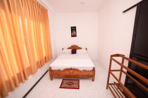 a bedroom with a bed and a large window at Chef Naturelle's Guest House in Kandy