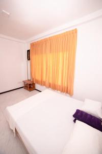 a bedroom with two beds and a window at Chef Naturelle's Guest House in Kandy