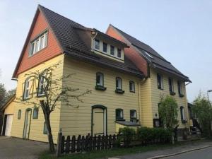 een groot geel huis met een bruin dak bij Komfortferienwohnung Heuboden in Sankt Andreasberg