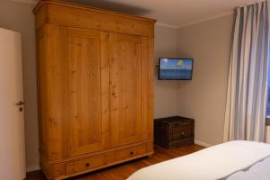 a wooden cabinet in a bedroom with a bed at Ora in Westermarkelsdorf