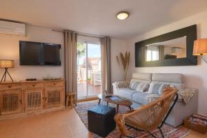 a living room with a couch and a tv at Jardines de Denia in Denia