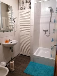 ein Badezimmer mit einem Waschbecken, einer Badewanne und einem WC in der Unterkunft Löwen Unterkunft Braunschweig in Braunschweig