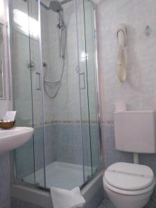 uma casa de banho com um chuveiro, um WC e um lavatório. em Hotel Twenty Nine em Gênova