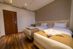 Habitación de hotel con 2 camas y toallas. en Hotel Samudra en Belgaum
